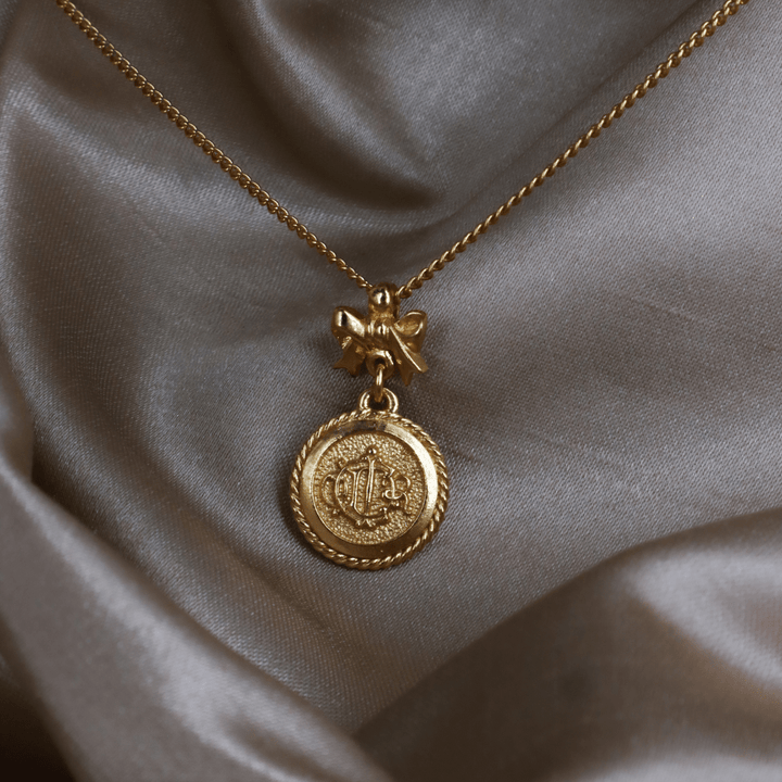 CHRISTIAN DIOR 絕版馬車硬幣蝴蝶結項鏈 - Vintasy