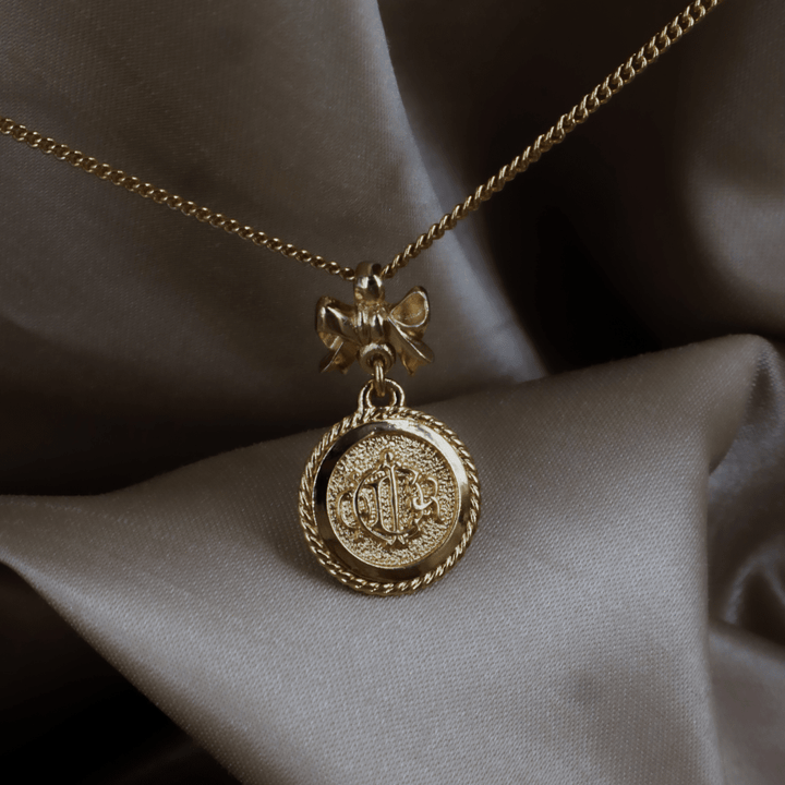 CHRISTIAN DIOR 絕版馬車硬幣蝴蝶結項鏈 - Vintasy