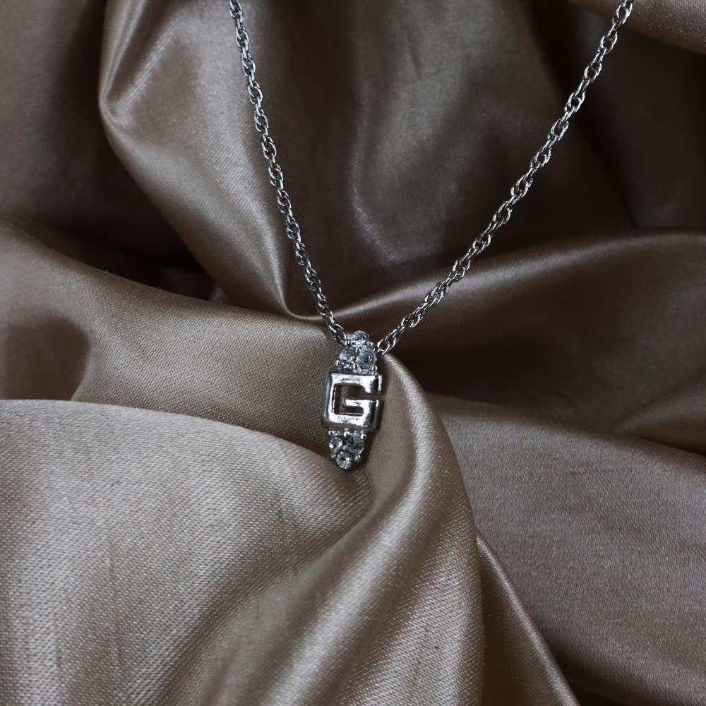 GIVENCHY 銀色 G Logo 閃石吊墜項鏈實物照 1，展示中央字母、透明石飾與扭紋鏈條