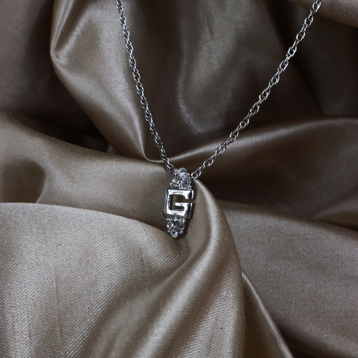 GIVENCHY 銀色 G Logo 閃石吊墜項鏈實物照 1，展示中央字母、透明石飾與扭紋鏈條