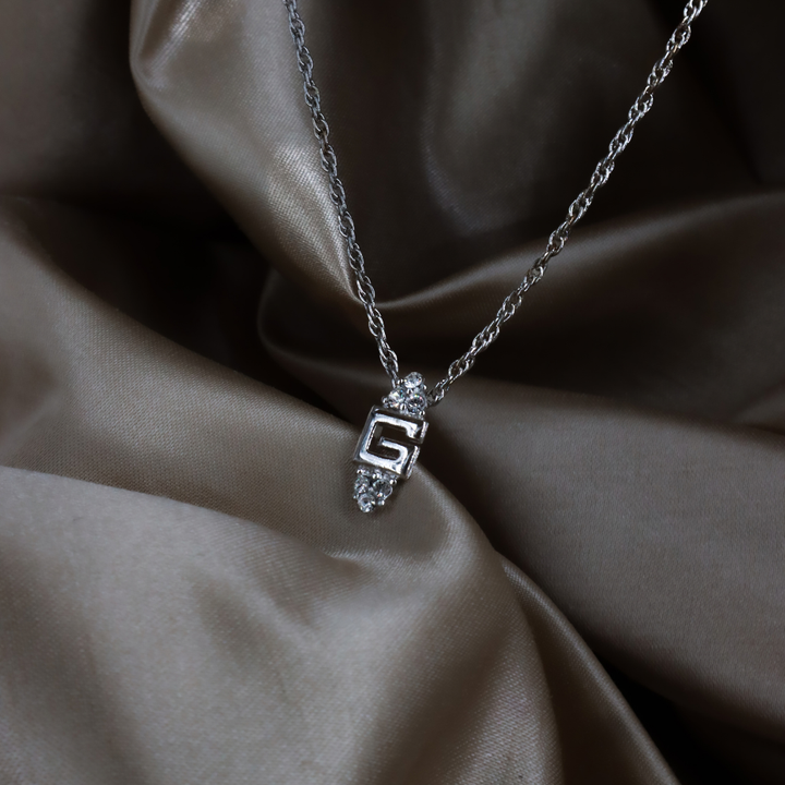 GIVENCHY 銀色 G Logo 閃石吊墜項鏈實物照 2，展示中央字母、透明石飾與扭紋鏈條