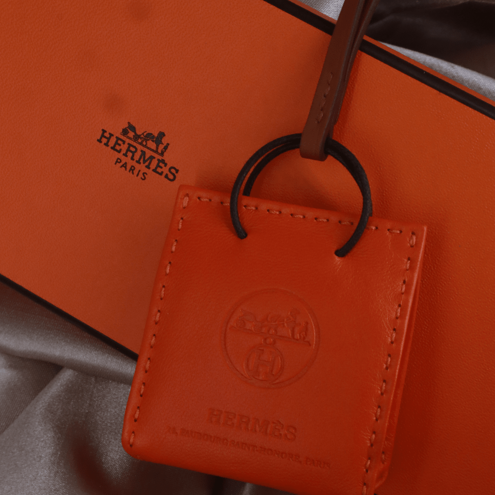 Hermès 橙色 Mini Shopping Bag Charm（Leather Bag Motif款）｜未使用附原盒 - Vintasy扣針