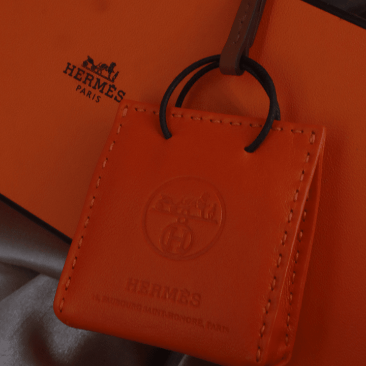 Hermès 橙色 Mini Shopping Bag Charm（Leather Bag Motif款）｜未使用附原盒 - Vintasy扣針