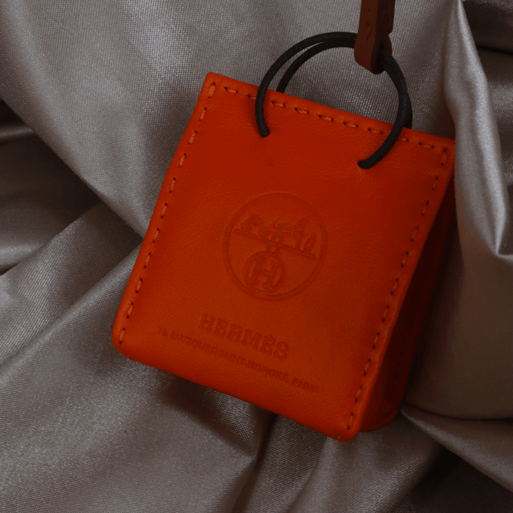 Hermès 橙色 Mini Shopping Bag Charm（Leather Bag Motif款）｜未使用附原盒 - Vintasy扣針