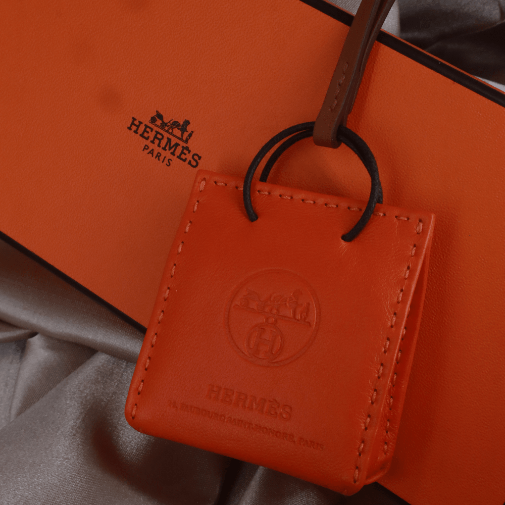 Hermès 橙色 Mini Shopping Bag Charm（Leather Bag Motif款）｜未使用附原盒 - Vintasy扣針