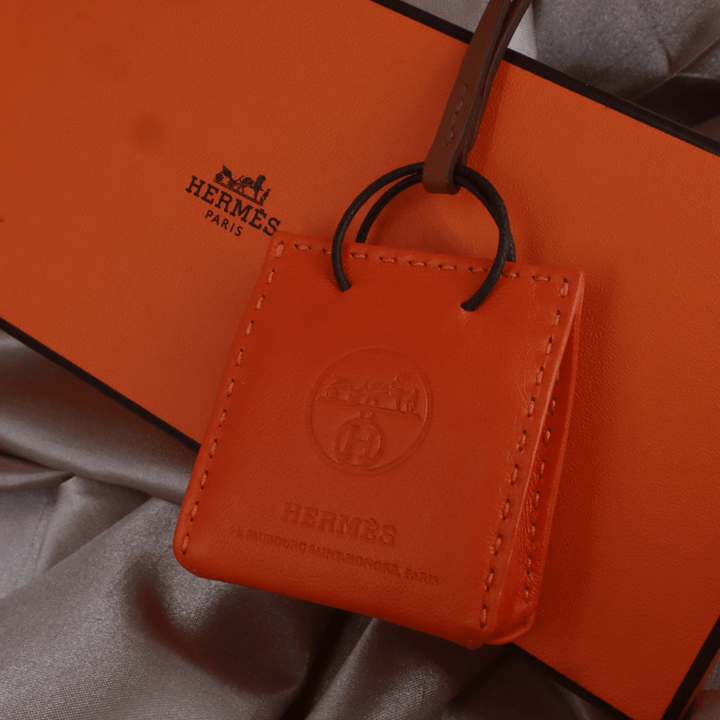 Hermès 橙色 Mini Shopping Bag Charm（Leather Bag Motif款）｜未使用附原盒 - Vintasy扣針